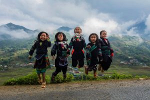 Five Hmong children jumping in the open air in Sa Pa